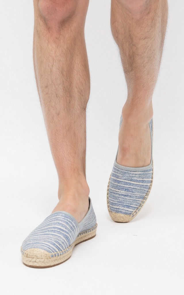 A male model wearing Espadrilles, against a white background, with a close   up of the feet